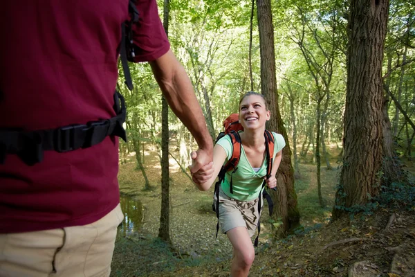 Jeune couple trekking en forêt et se tenant la main — Photo