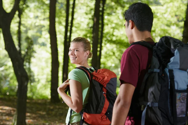 Couple avec sac à dos faisant du trekking en bois — Photo