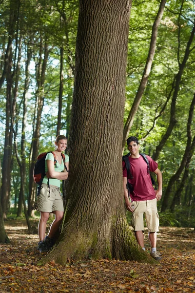 Behoud van het milieu: jonge wandelaars leunend op boom — Stockfoto