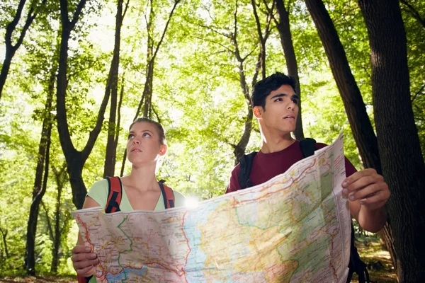 Junges Paar schaut bei Wanderung auf Landkarte — Stockfoto