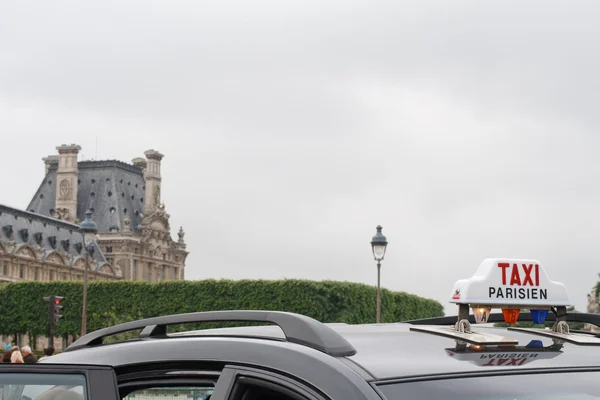 Parijse taxi teken op de achtergrond van het louvre — Stockfoto