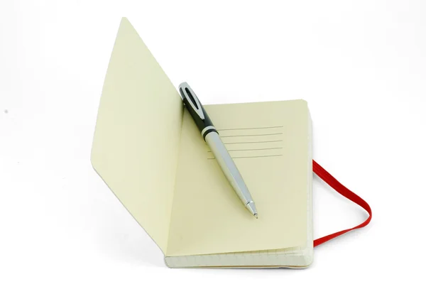 Zilveren pen op gele voorpagina van de notebook — Stockfoto