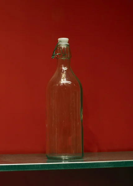 Flaska med en röd abckground — Stockfoto