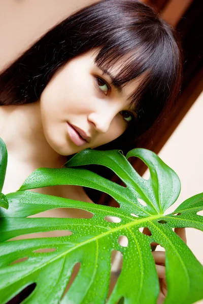 Girl with green leaves in garden — Stock Photo, Image