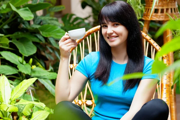 Girl with cup of coffee in garden — Stock Photo, Image