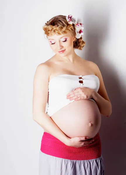 Zwangere vrouw met orchideebloem in haar — Stockfoto