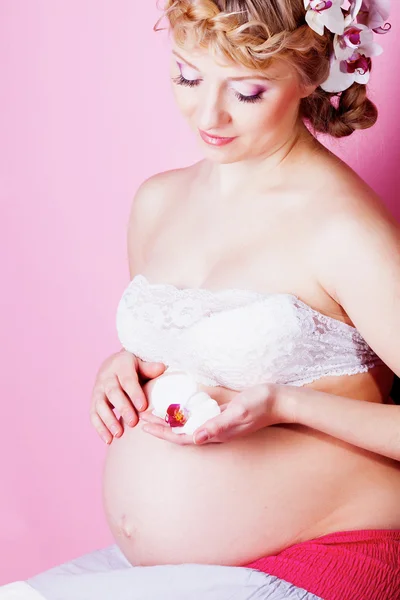 妊娠中の女性の髪の蘭の花を持つ — ストック写真