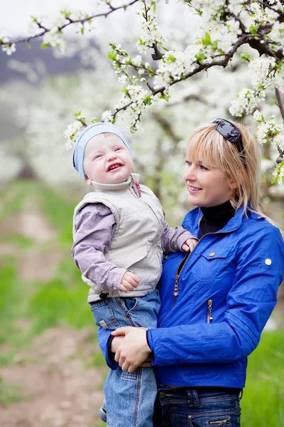 Мати з дитиною в квітучому саду — стокове фото