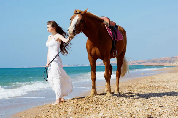 Девушка с лошадью на пляже — стоковое фото