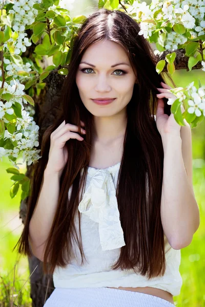 Brunett tjej i blomma trädgård — Stockfoto