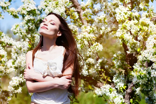 Brunett tjej i blomma trädgård — Stockfoto