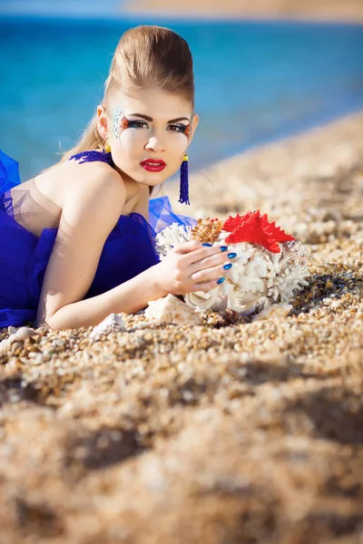Jenta med skjell på stranda. – stockfoto