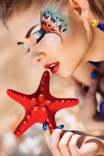Lány a tengeri kagylókból a strandon — Stock Fotó