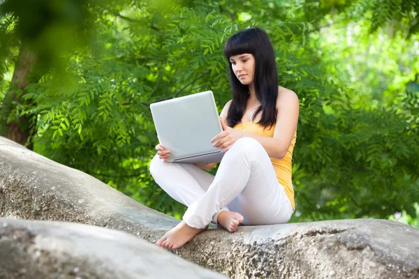 Meisje met laptop in het park — Stockfoto