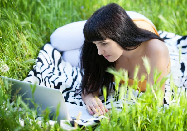Девушка с ноутбуком в парке — стоковое фото