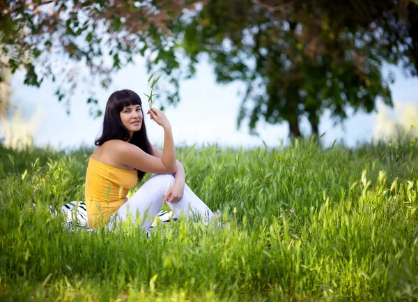 Dívka sedící v trávě — Stock fotografie
