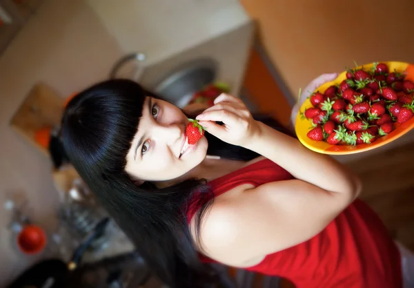 Girl with strawberry on the kitchen — Stock Photo, Image