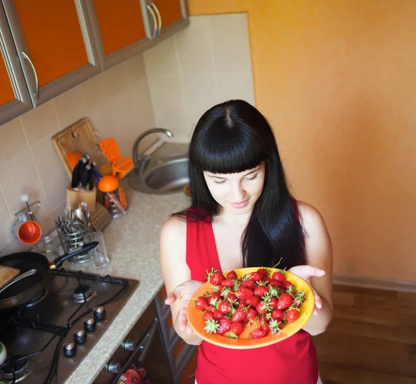 Girl with strawberry on the kitchen — Stock Photo, Image