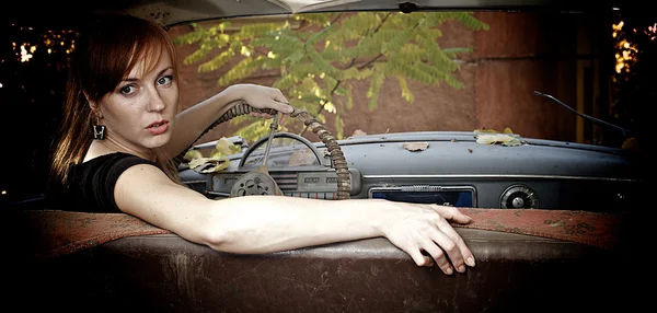Ung kvinna i den gamla bilen — Stockfoto