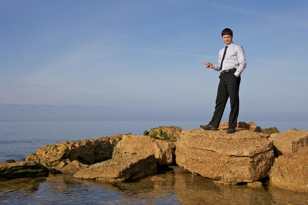 Businessman shows his hand at sea — Stock Photo, Image