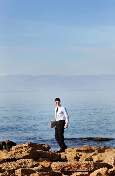 Homem perto do mar com laptop — Fotografia de Stock