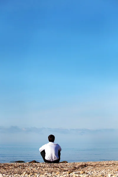 Man zitplaatsen op de kust — Stockfoto