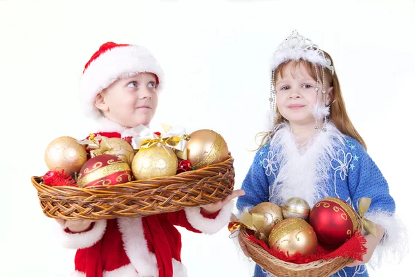 Kleines Mädchen und Junge in Weihnachtskleidung mit Spielzeug — Stockfoto