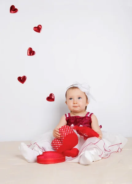 Little girl with flying hearts in studio — Stock Photo, Image