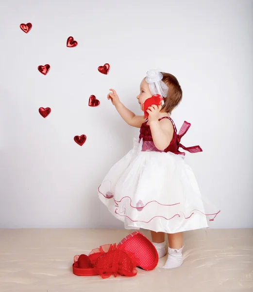 Kleines Mädchen mit fliegenden Herzen im Studio — Stockfoto