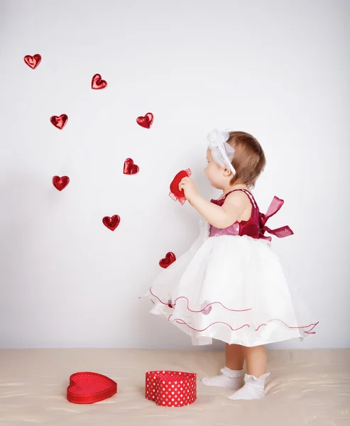 Маленькая девочка с летающими сердцами в студии — стоковое фото