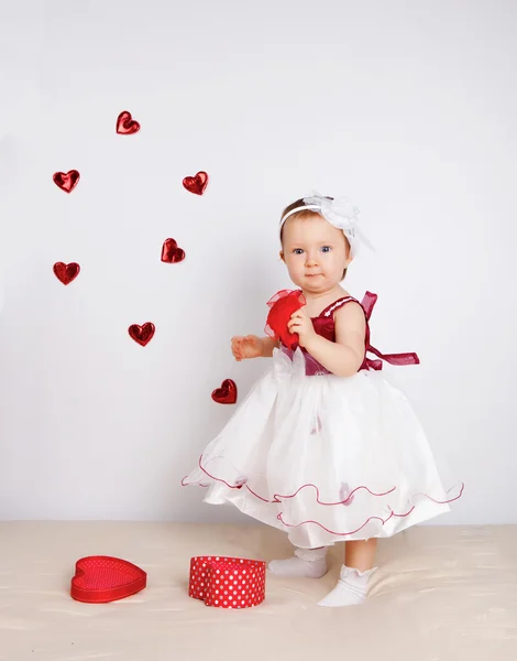 Kleines Mädchen mit fliegenden Herzen im Studio — Stockfoto