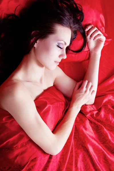 Girl sleeping on red silk — Stock Photo, Image