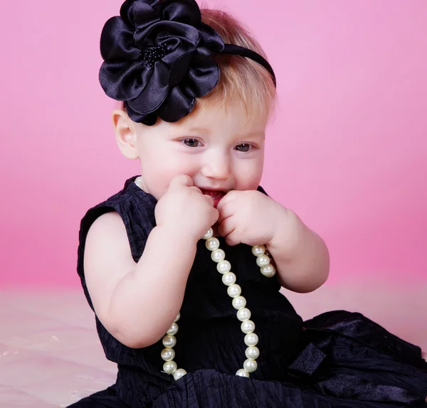 Маленькая девочка в черном платье в студии — стоковое фото