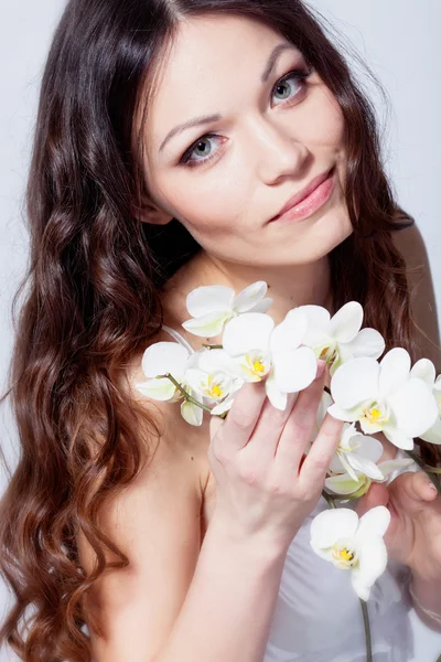 Beautiful brunette with orchid flowers Stock Picture