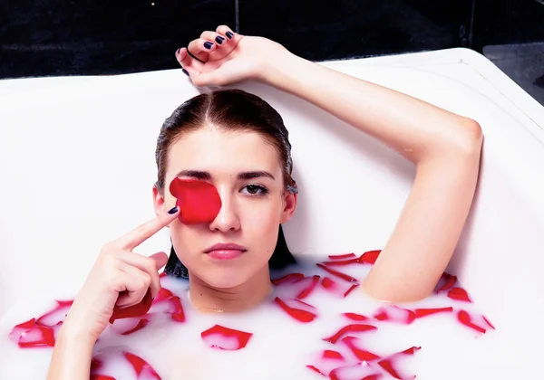 Girl in bath with rose petals — Stock Photo, Image