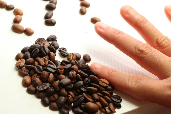 Kaffeebohnen und menschliche Hand — Stockfoto