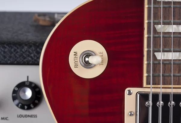 Nahaufnahme einer E-Gitarre, die sich an einen Vintage-Verstärker lehnt — Stockfoto
