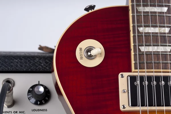 Nahaufnahme einer E-Gitarre, die sich an einen Vintage-Verstärker lehnt — Stockfoto