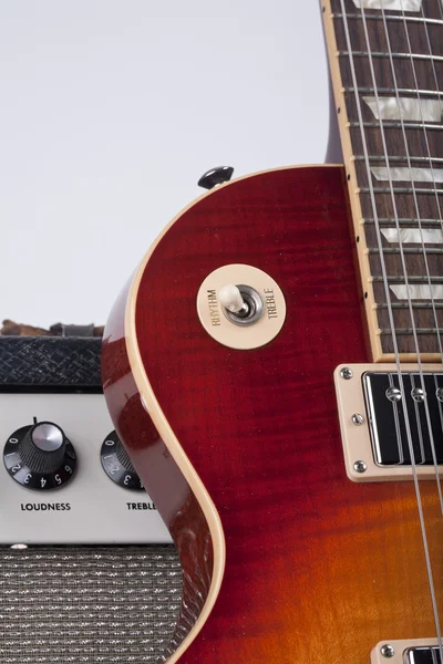 Gros plan de la guitare électrique Sunburst appuyée contre un amplificateur vintage — Photo