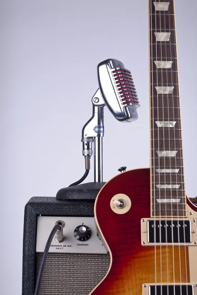 Guitarra eléctrica Sunburst apoyada contra un viejo amplificador —  Fotos de Stock