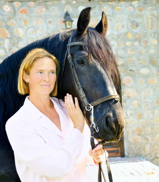 Mulher bonita com cavalo preto bonito — Fotografia de Stock