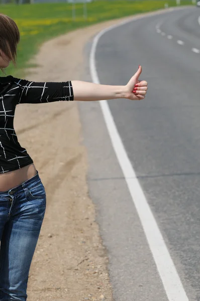 Hitchhiking girl on the road — Stock Photo, Image