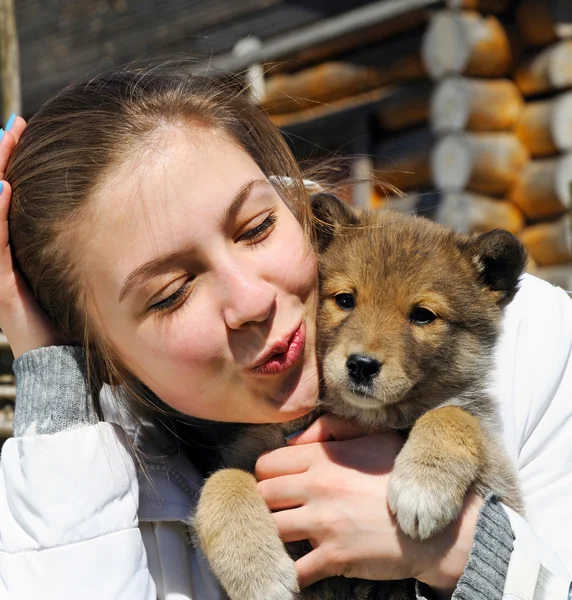 Giovane bella ragazza bacia un cucciolo — Foto Stock