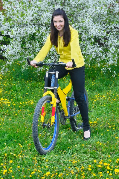 Mujer sobre hierba verde con bicicleta —  Fotos de Stock