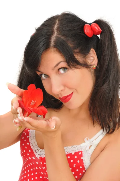 Ung kvinna med röd blomma tittar på kameran — Stockfoto