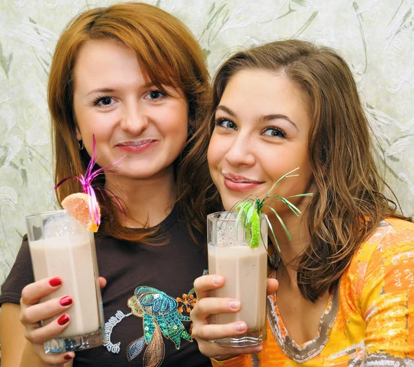Två vackra skrattande flickor dricka drinkar med frukter — Stockfoto