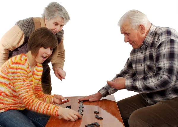 Prarodiče a vnučka hrát domino na stůl — Stock fotografie
