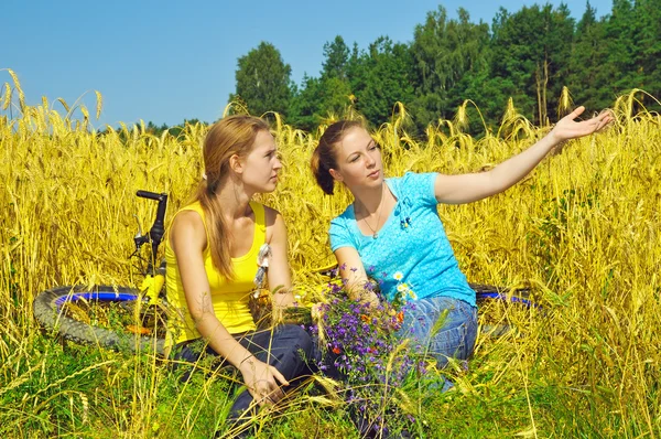 Две красивые девушки наслаждаются зрелищем в золотом поле — стоковое фото
