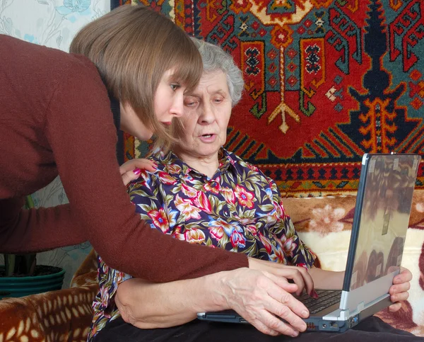 Бабушка и внучка смотрят на ноутбук — стоковое фото