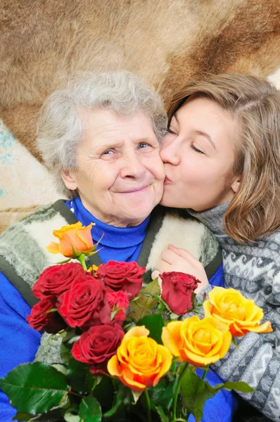 Enkelin küsste Großmutter — Stockfoto